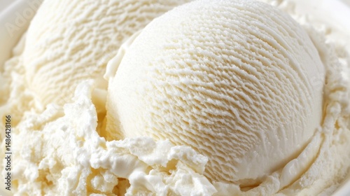 Two scoops of vanilla ice cream.  A close-up view of creamy, smooth, vanilla ice cream scoops nestled in a bowl, topped with whipped cream.  The texture of the ice cream is visible