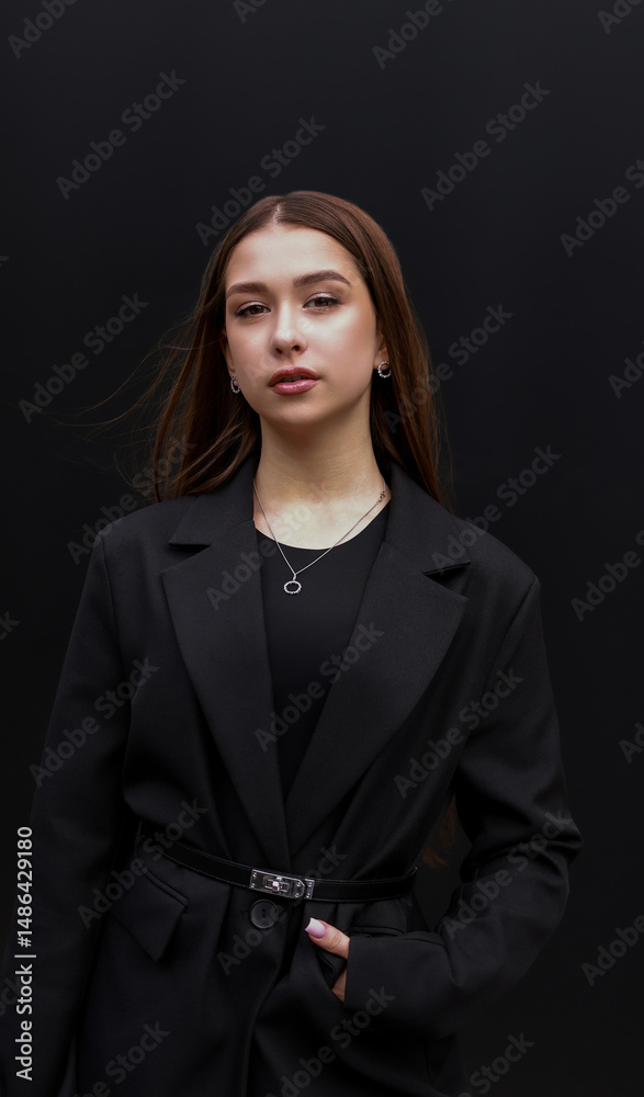 Brunette girl in a black jacket on a black background. Brunette girl in a black jacket on a black background.