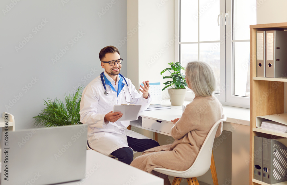 Fototapeta premium Positive doctor or nurse is talking to an elderly patient during a hospital visit. The medical professional is providing healthcare and therapy, engaging in a conversation with the patient.