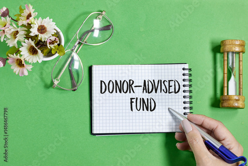 Donor-Advised Fund Concept with Notebook, Pen, and Symbolic Objects on Green Background