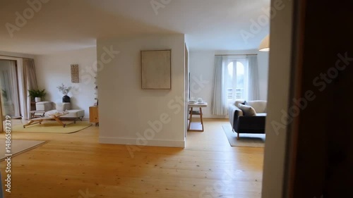 View into bright living area with natural light and light wood flooring.