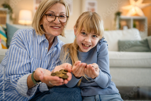 Foto grandmother and grandchild save money together at piggy bank