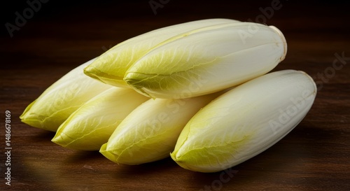 Elegant pile of Belgian endives on rustic wooden surface in still life composition