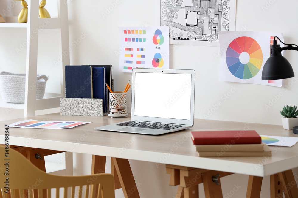 Fototapeta premium Workplace with blank laptop in light room