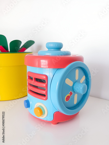 Music box. Multicolor toy cylindrical shaped with rotary handle for children.