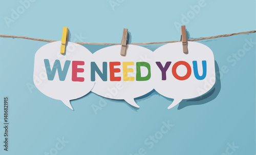 Colorful 'We Need You' message on speech bubbles hanging on a string.