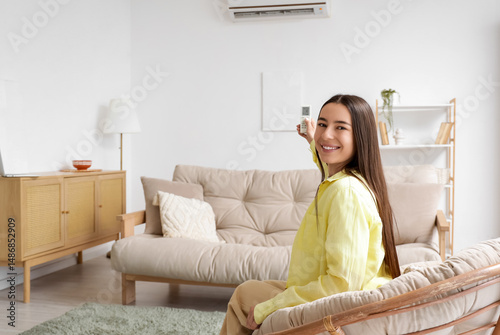 Young woman in armchair swi...