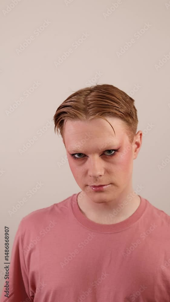 A Vertical Close-up of a Man Holding Makeup Brush Posing with Finished Look
A young man poses confidently with a finished makeup look, holding a colorful makeup brush to the side of his face. A Vertical Close-up of a Man Holding Makeup Brush Posing with Finished Look
A young man poses confidently with a finished makeup look, holding a colorful makeup brush to the side of his face.