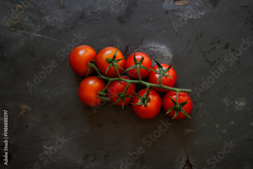 Bunch of vine ripened tomatoes on black background