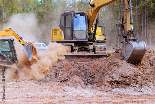 Excavators, bulldozers clear construction site, moving soil, debris on clear day.