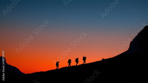 A journey worth every step--four hikers press forward through the mountains, silhouettes set against the brilliant sunset sky.