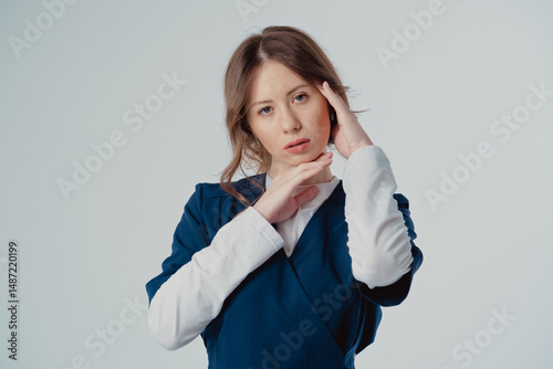 Portrait of a cardiologist girl in a blue uniform with her hands near her face on a white background, with copy space to the side.