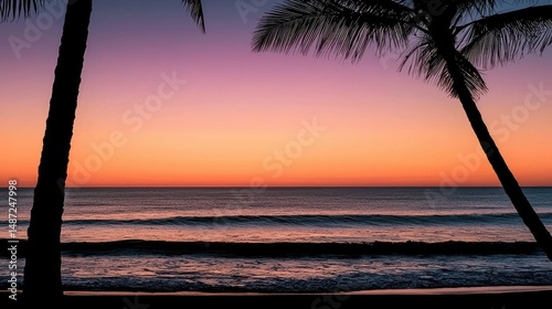 Sunset colors over ocean framed by silhouetted palm trees