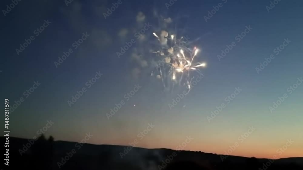 Golden and red fireworks illuminating the night sky during sunset  
