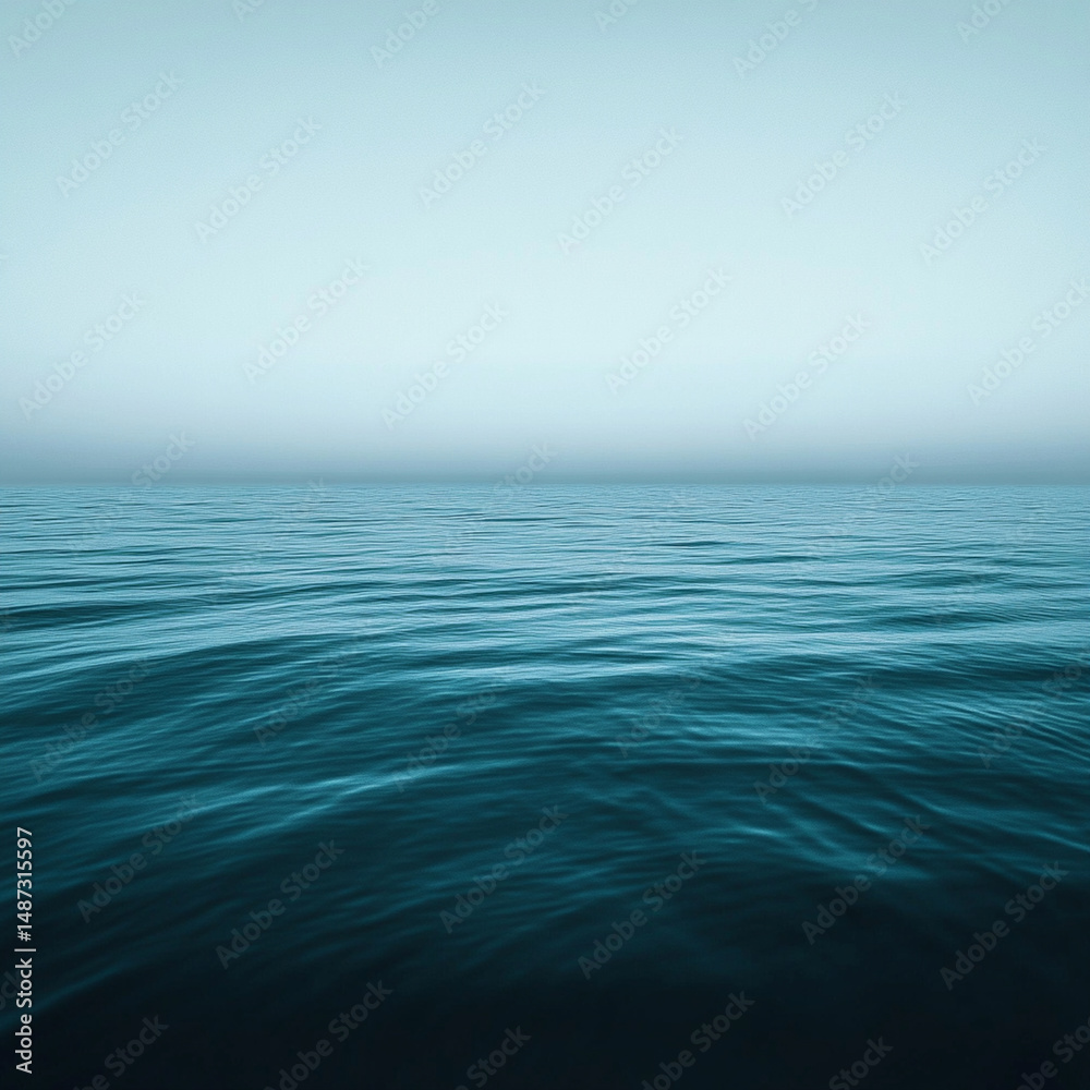 Obraz premium Dark teal ocean surface with gentle ripples meets a muted, low horizon under an overcast sky, ideal for a moody website header or editorial visual.