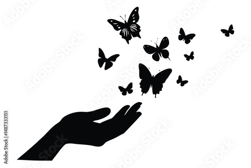 Black butterflies are flying away from a dark silhouette hand on white background