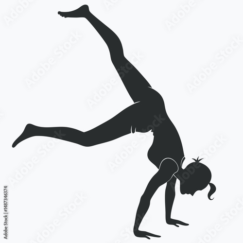 Silhouette of woman performing yoga handstand pose with legs extended in air