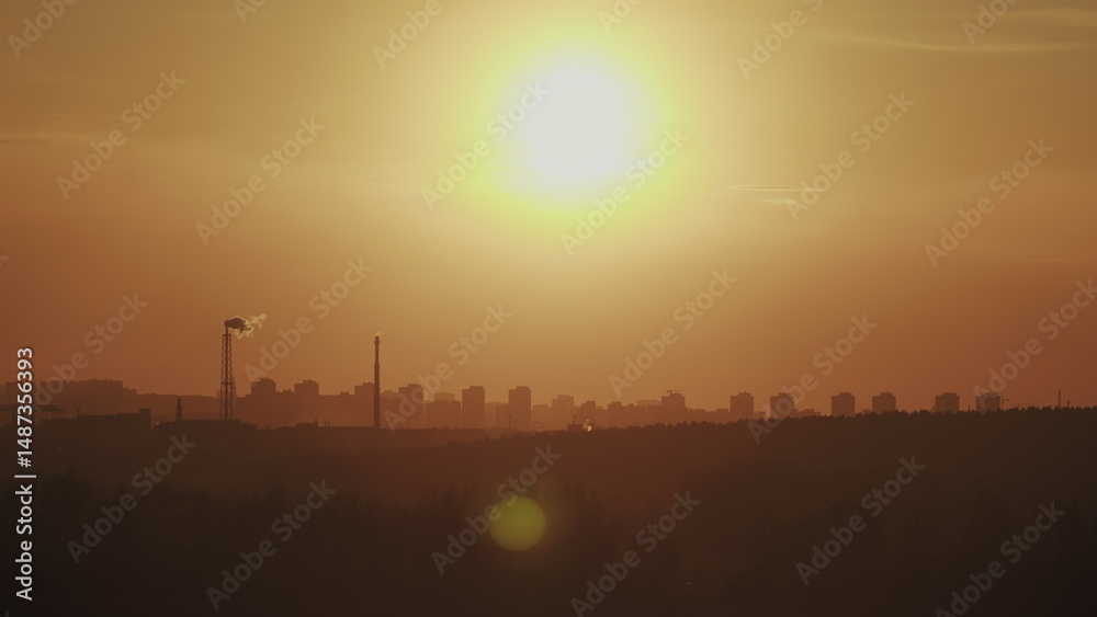 Fototapeta premium An industrial sunset glows over the cityscape, blending natures tranquility with urban life