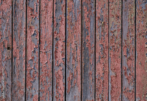 The texture of wood, wooden boards, peeling red paint on wood, background wood planks