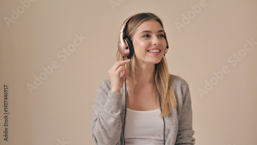 Harmony in Sound: A beautiful girl with headphones, absorbed in the auditory world. She listens attentively, her eyes lighting up with peace and enjoyment.