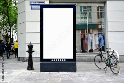 Fototapeta Naklejka Na Ścianę i Meble -  blank digital ad panel. billboard display. empty white lightbox sign on a popular shopping street. mockup template. city transit station. European street setting. outdoor advertising.