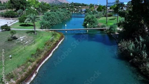 Aerial: Drone Backward Shot Of People Swimming In River At Kibbutz Community On Sunny Day - Nir David, Israel