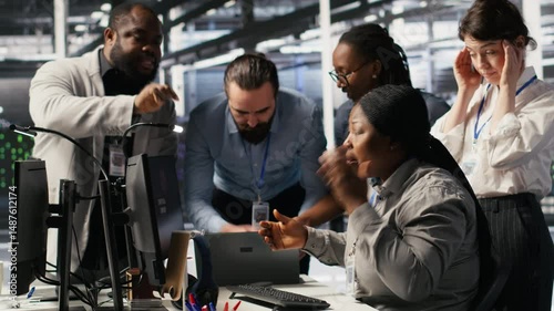 Engineering team in data center panicking after receiving critical error popup on PC monitor. Server room coworkers alerted by bugs causing low gear performance while troubleshooting systems, camera A