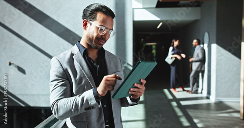 Businessman, research and browsing with tablet at office building for company report or review. Man, employee or investor on technology in hallway for corporate analysis or communication at workplace