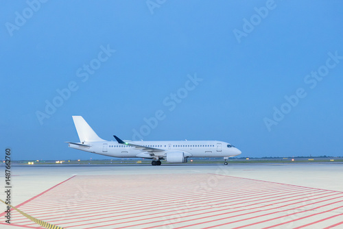 Airplane on airport runway at sunset