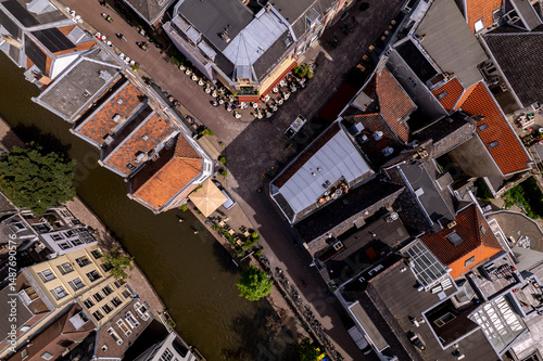 Fototapeta Naklejka Na Ścianę i Meble -  Aerial top down view on Oude Gracht canal in Utrecht, The Netherlands, with warehouse mansion waterway homes and small terrace on the street corner