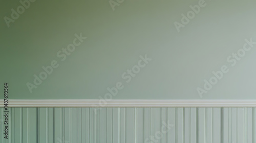 Elegant wall features beadboard paneling painted in a soft sage green, complemented by a smooth, matching painted wall and detailed white molding. photo