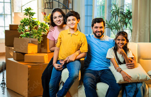 Εκτύπωση καμβά Happy Indian parents and kids relaxing on couch after shifting to their new hous