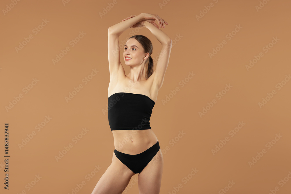 Obraz premium Beautiful woman with perfect slim body on beige background