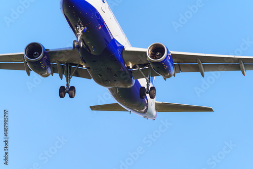 Close-up of an approaching passenger airplane preparing to land. Clear sky in the background.