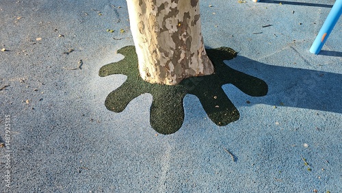 Tree surrounded by artistic rubber flooring in a children’s playground