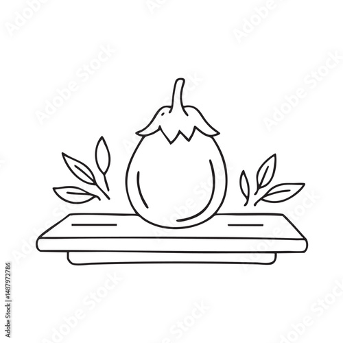 A Thai eggplant lying beside fresh herbs on a cooking table