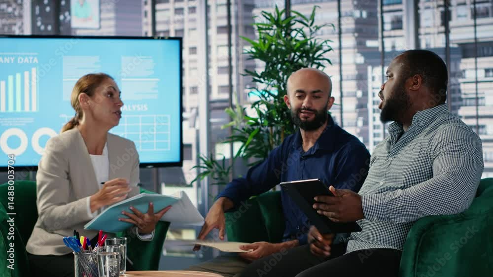 Corporate leadership team in a business meeting use data driven analysis and strategic thinking to identify insights and guide executive decisions across a global company. Camera B.