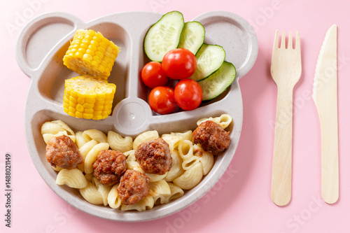 Baby food on a plate. Wooden fork and knife. Lunch or dinner option for a child.