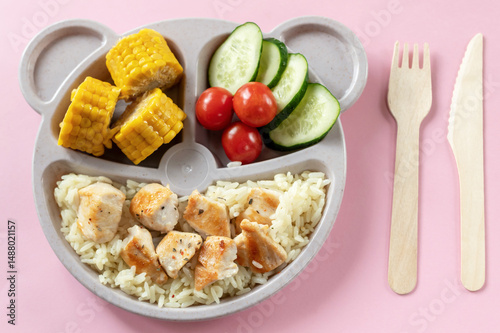 Baby food on a plate. Wooden fork and knife. Lunch or dinner option for a child.