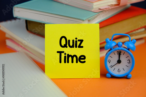 the words Quiz Time on yellow notepad over orange background the concept of answering quizzes or quiz games
