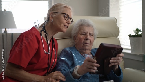 A caregiver interacts warmly with an elderly woman, sharing a moment of connection and reminiscing in a healthcare facility during the daytime.
