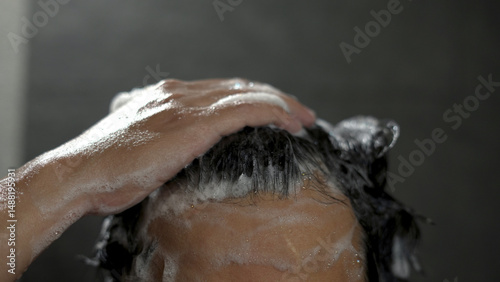 A man washes his hair with anti-dandruff shampoo.. photo