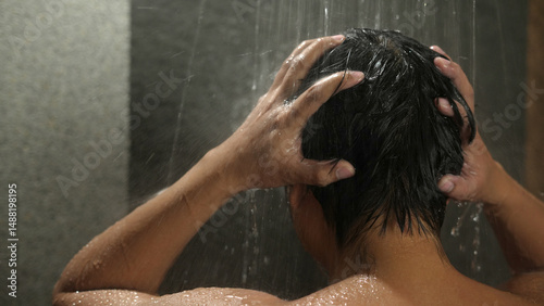 A man washes his hair with anti-dandruff shampoo. photo