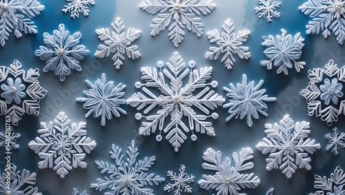 Close-up view of intricate snowflake patterns against a frosted blue background, capturing winter beauty