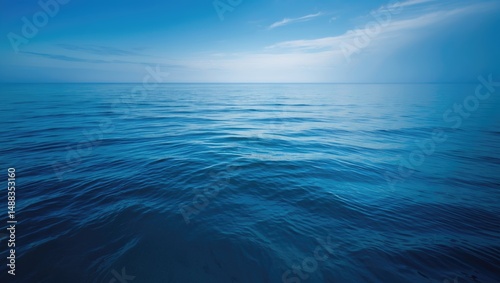 Beautiful natural beach scene with clear water, light clouds, and the horizon under a sunny blue sky, perfect for tourism and relaxation.