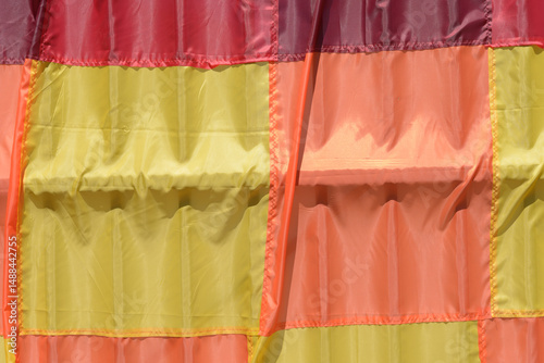 yellow orange red fabric swatches sewn together hanging outside