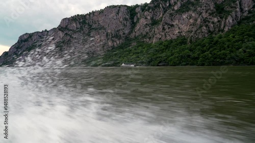 water splashes behind the boat on the Danube among mountains and forests, 4k