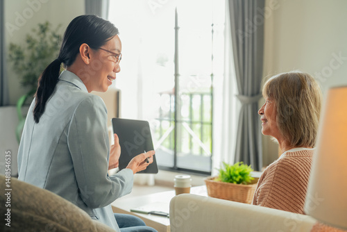 Asian retired old woman with Financial advisor talking Authentic shot of asian elderly couple want to manage retired plan discussion with financial management at home	