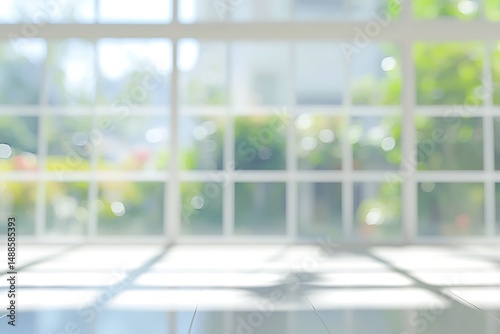 Blurred view through large window with white to plants outside, daytime