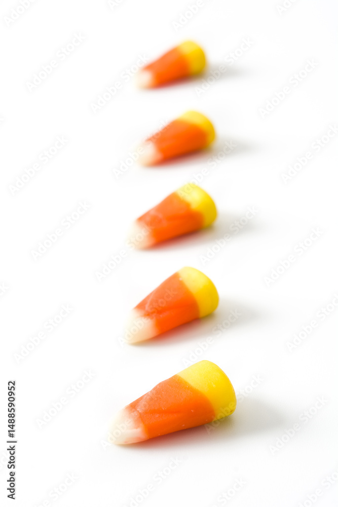 Candy corn candies making a diagonal line on white background Candy corn candies making a diagonal line on white background
